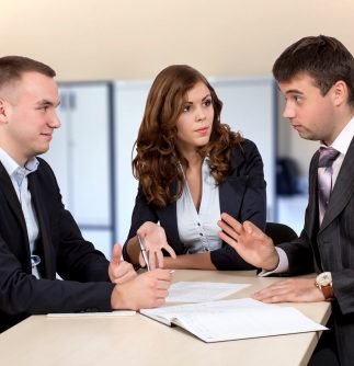 Three business people discuss the deal